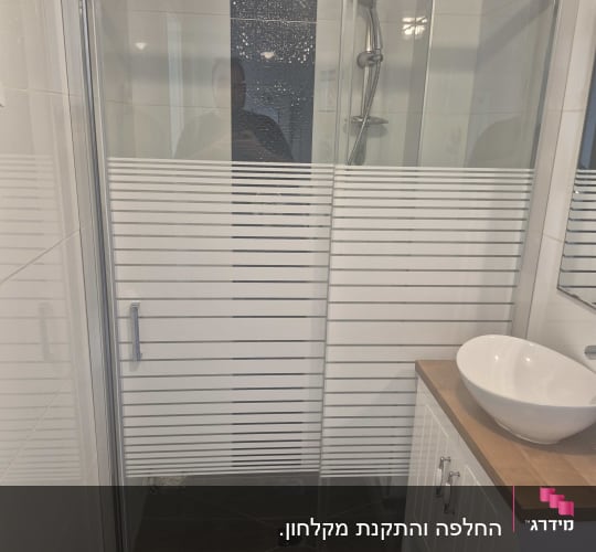 מקלחון זכוכית עם דלת הזזה וחדר אמבטיה